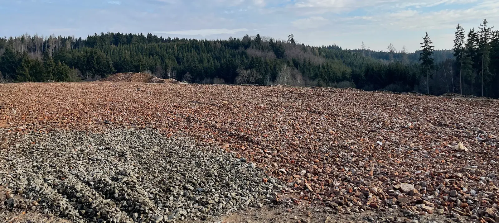 Recyklační středisko Housko — zpevněná plocha s recyklátem, v pozadí les
